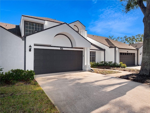 view of front of property with a garage, driveway, and stucco siding