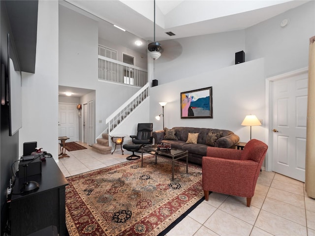 living room featuring stairway, visible vents, high vaulted ceiling, and light tile patterned flooring