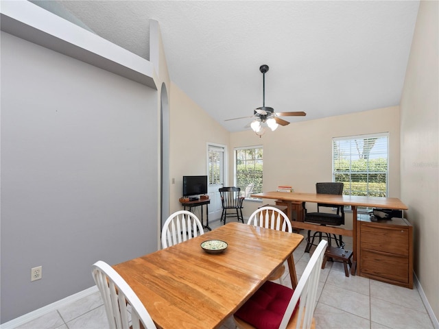 dining area featuring lofted ceiling, light tile patterned floors, a textured ceiling, a ceiling fan, and baseboards