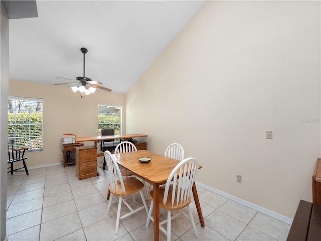 dining space with high vaulted ceiling, ceiling fan, baseboards, and light tile patterned floors