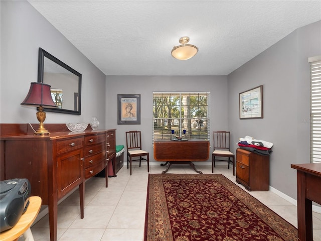 sitting room featuring a textured ceiling, baseboards, and light tile patterned floors