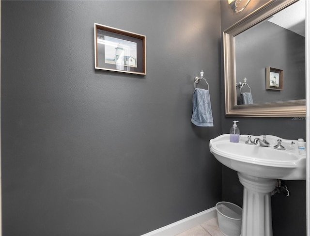 bathroom with a sink, tile patterned flooring, and baseboards