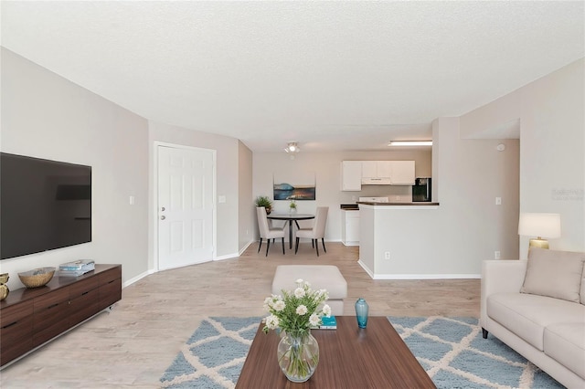 living room with a textured ceiling and light wood-type flooring