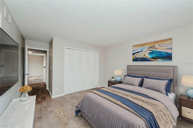 bedroom with a closet, hardwood / wood-style floors, and a textured ceiling