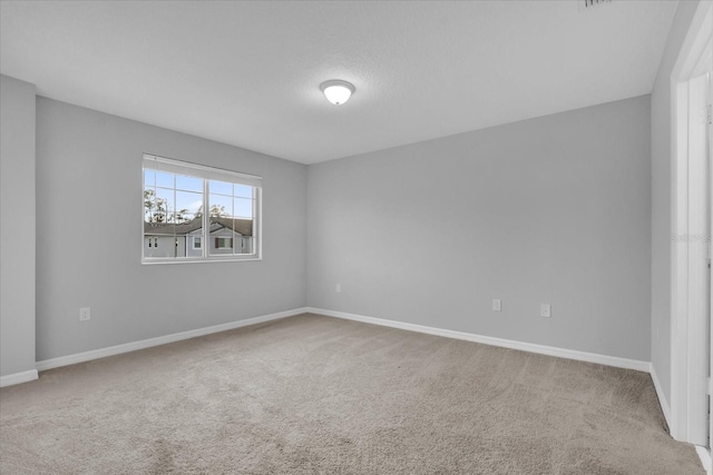 spare room featuring a textured ceiling and carpet flooring