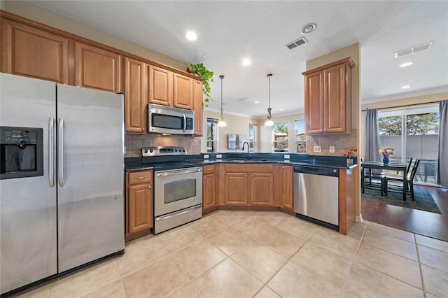 kitchen featuring stainless steel appliances, a wealth of natural light, pendant lighting, and light tile patterned floors