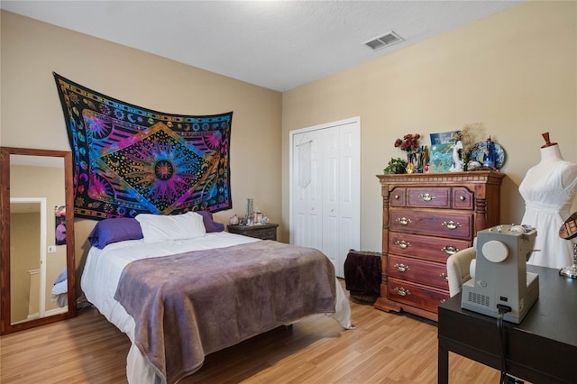 bedroom with light hardwood / wood-style floors and a closet