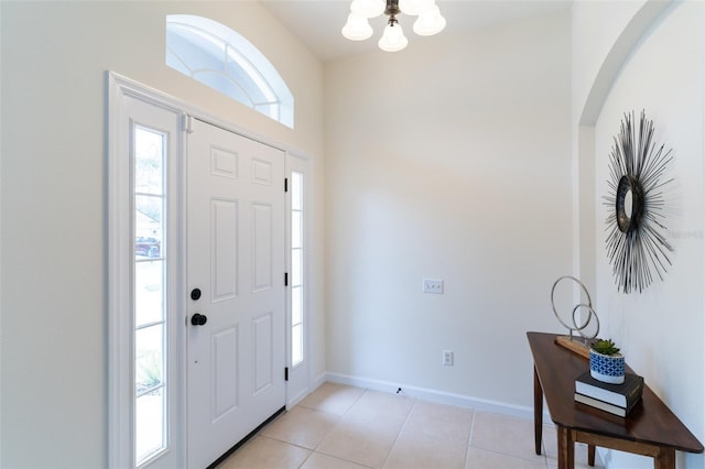 tiled foyer entrance with an inviting chandelier