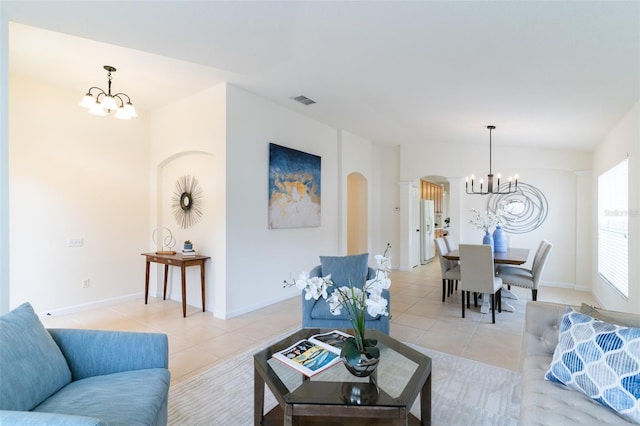 living room with light tile patterned floors and a notable chandelier