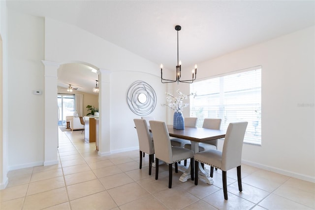 tiled dining space with ceiling fan with notable chandelier