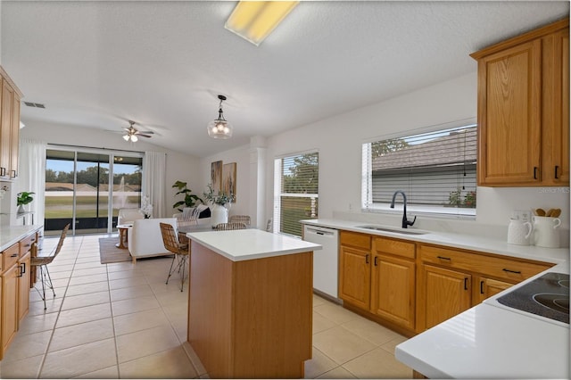 kitchen with dishwasher, a center island, light tile patterned floors, pendant lighting, and sink