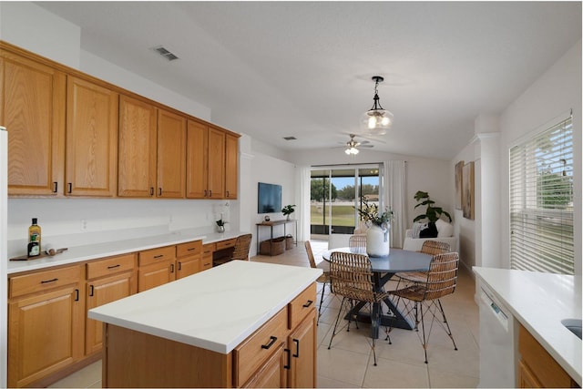 kitchen with decorative light fixtures, ceiling fan, light tile patterned floors, white dishwasher, and a kitchen island