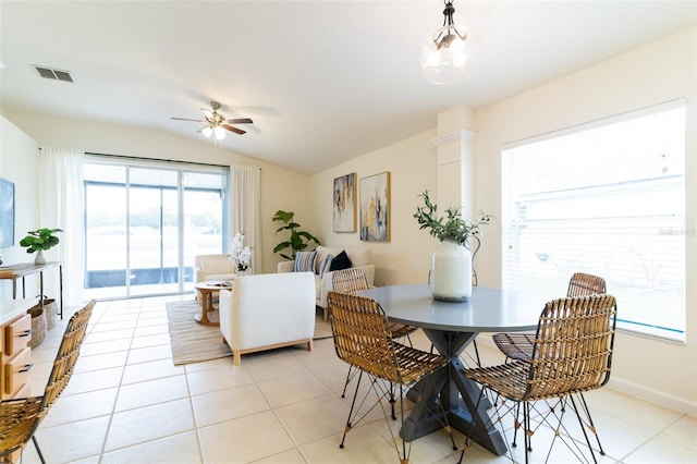 tiled dining room with ceiling fan and lofted ceiling