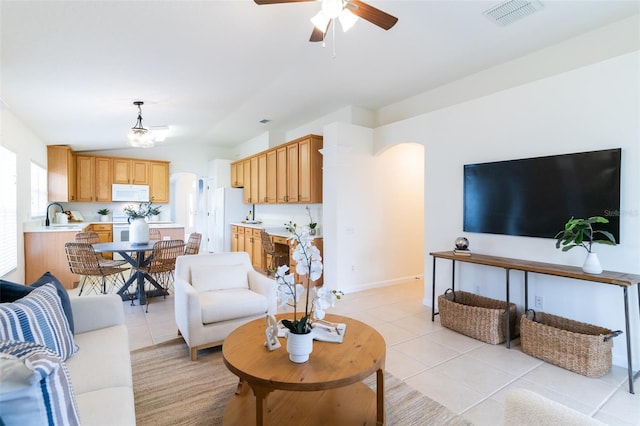 living room with sink, ceiling fan with notable chandelier, and light tile patterned floors