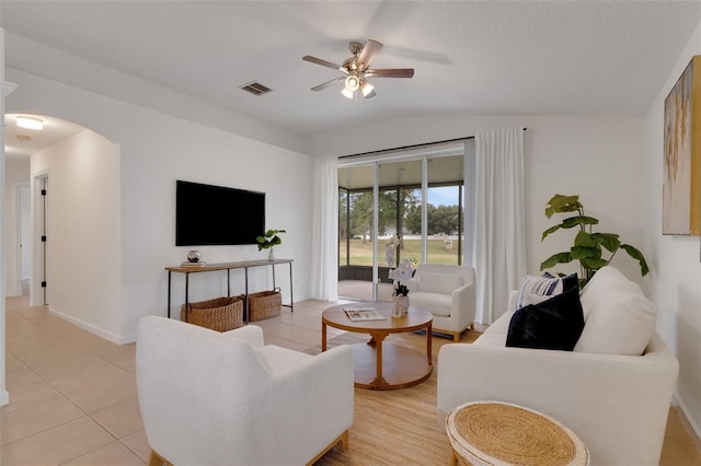 tiled living room with lofted ceiling, a textured ceiling, and ceiling fan