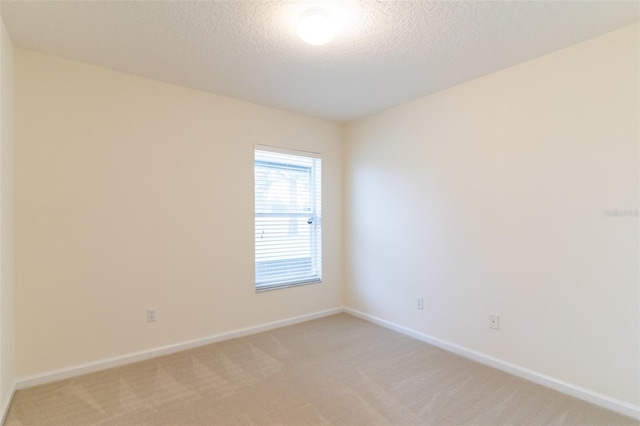 carpeted spare room featuring a textured ceiling