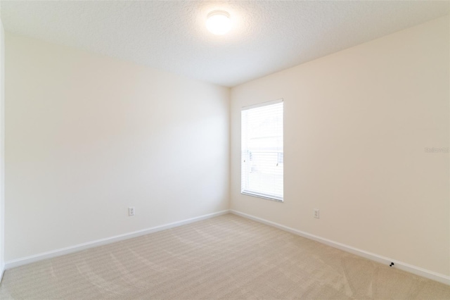 unfurnished room with a textured ceiling and light colored carpet