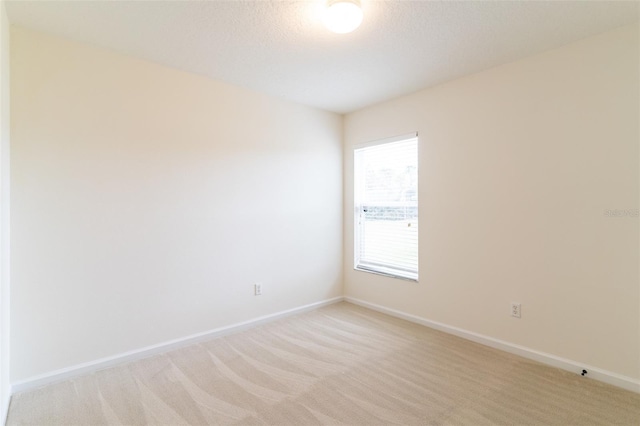 unfurnished room with a textured ceiling and light carpet