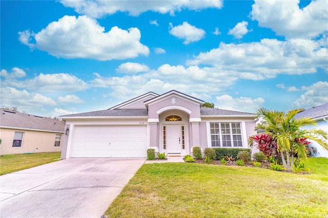 ranch-style home featuring a garage and a front lawn