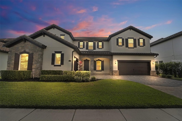 view of front of home featuring a garage and a yard