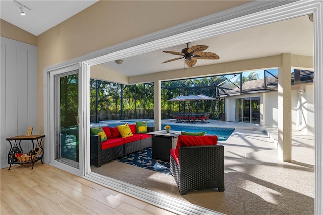 view of patio / terrace featuring an outdoor hangout area, ceiling fan, and glass enclosure