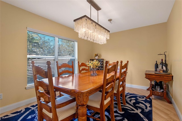 dining area featuring light hardwood / wood-style flooring and an inviting chandelier