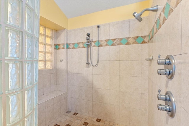 bathroom featuring vaulted ceiling and a tile shower