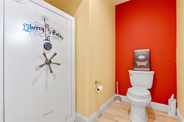 bathroom with toilet and hardwood / wood-style flooring