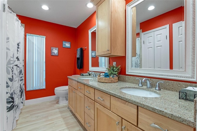 bathroom with toilet, vanity, and hardwood / wood-style floors