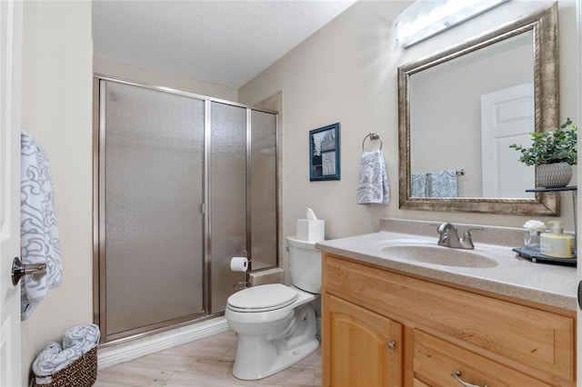 bathroom with walk in shower, vanity, and toilet