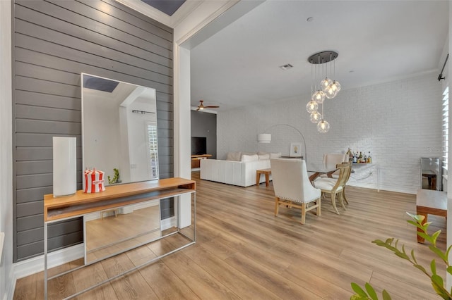 interior space with brick wall, hardwood / wood-style floors, and ceiling fan