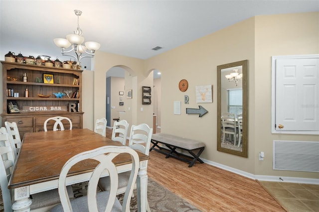 dining area with an inviting chandelier and light hardwood / wood-style floors