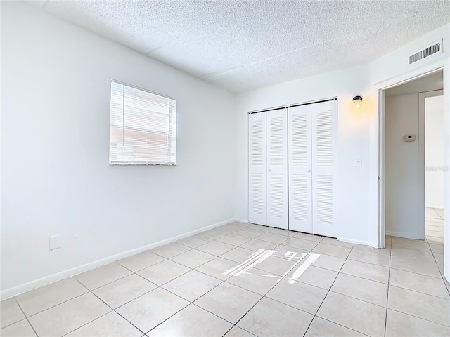 unfurnished bedroom with a closet and light tile patterned flooring