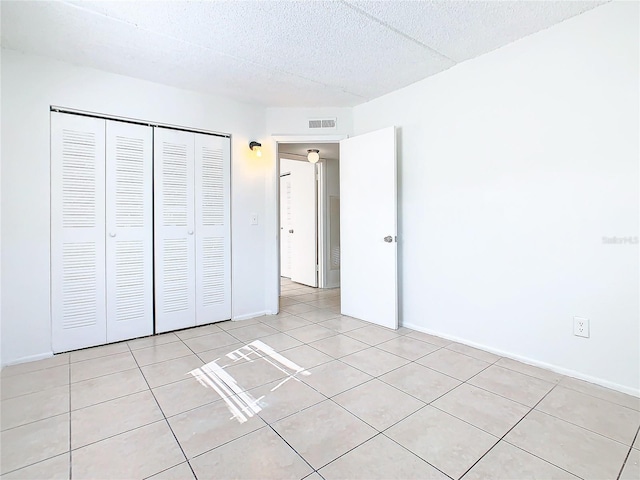 unfurnished bedroom featuring light tile patterned floors and a closet