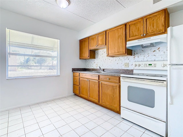 kitchen with sink, white appliances, and light tile patterned flooring