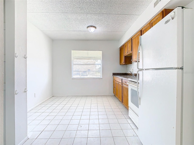 kitchen with light tile patterned flooring, sink, and white appliances