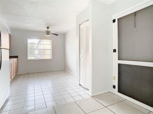 interior space with ceiling fan and light tile patterned flooring