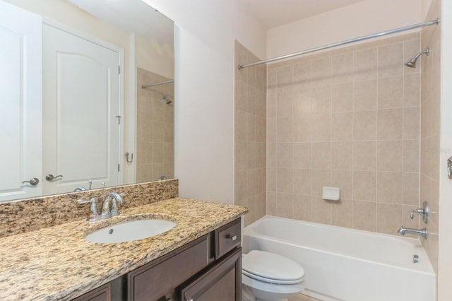 full bathroom with vanity, tiled shower / bath combo, and toilet