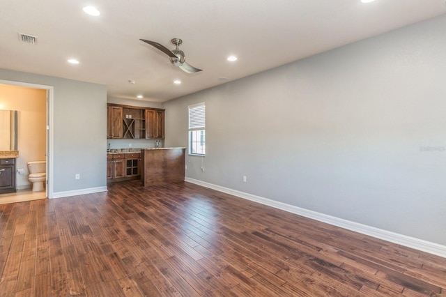 unfurnished living room with ceiling fan and dark wood-type flooring