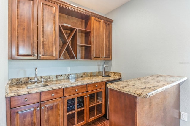 bar featuring light stone counters and sink