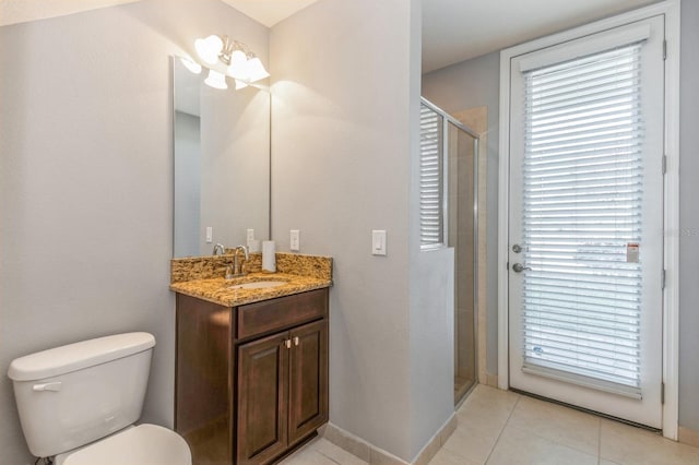 bathroom featuring toilet, vanity, tile patterned flooring, and walk in shower