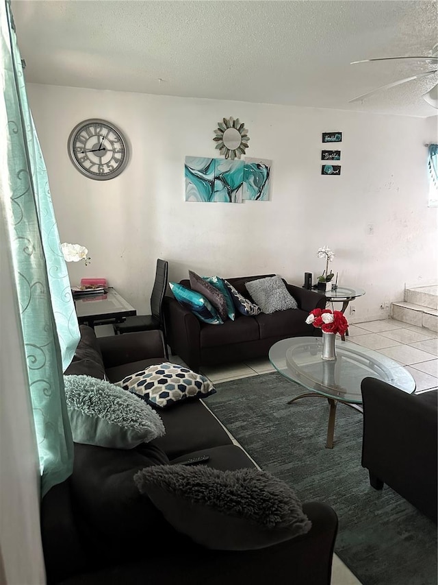 living room with a textured ceiling and ceiling fan