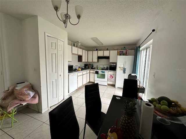 kitchen featuring white appliances, a notable chandelier, light tile patterned flooring, and hanging light fixtures