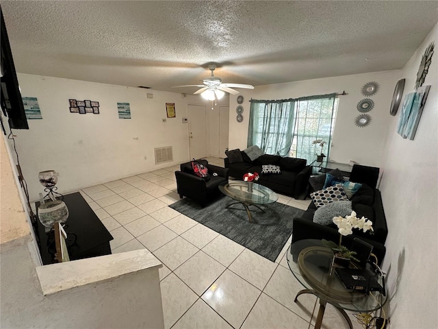 living room featuring a textured ceiling, ceiling fan, and tile patterned floors