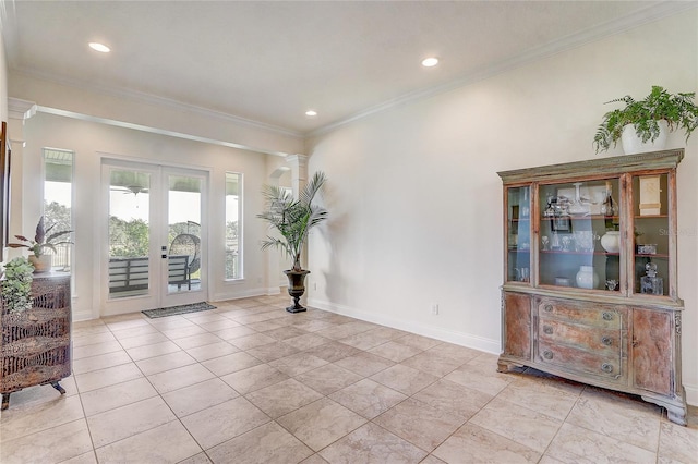 tiled foyer featuring french doors, ornamental molding, and decorative columns