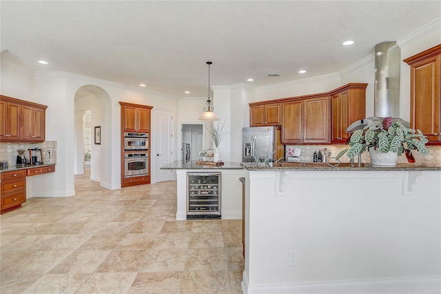 kitchen featuring a kitchen bar, stainless steel appliances, backsplash, wine cooler, and wall chimney range hood