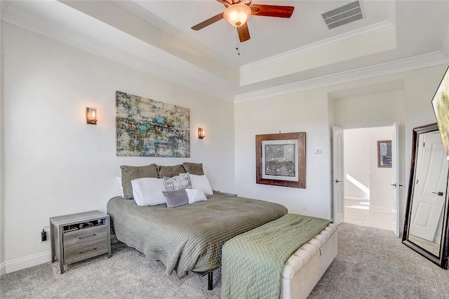 carpeted bedroom featuring ceiling fan, crown molding, and a tray ceiling