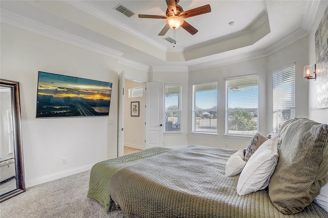 bedroom with ceiling fan, crown molding, a tray ceiling, and carpet flooring