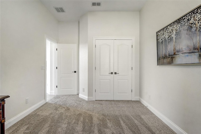 unfurnished bedroom featuring carpet floors and a closet