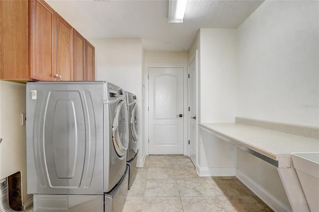 laundry room with a textured ceiling, cabinets, and independent washer and dryer